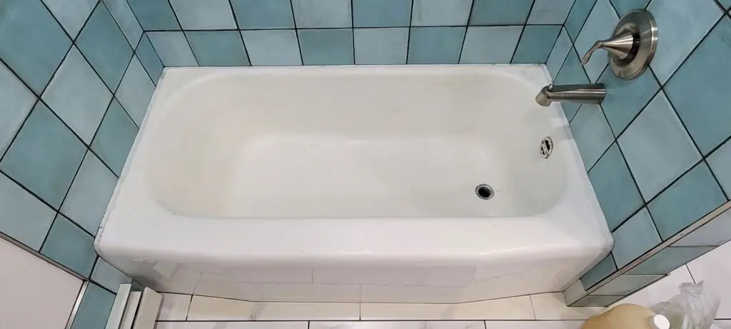 A white bathtub with a large drain
