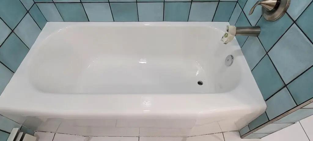 A white bathtub with a small drain