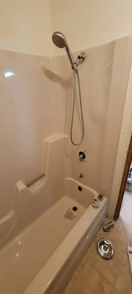 Cream-colored Tub with a shower head