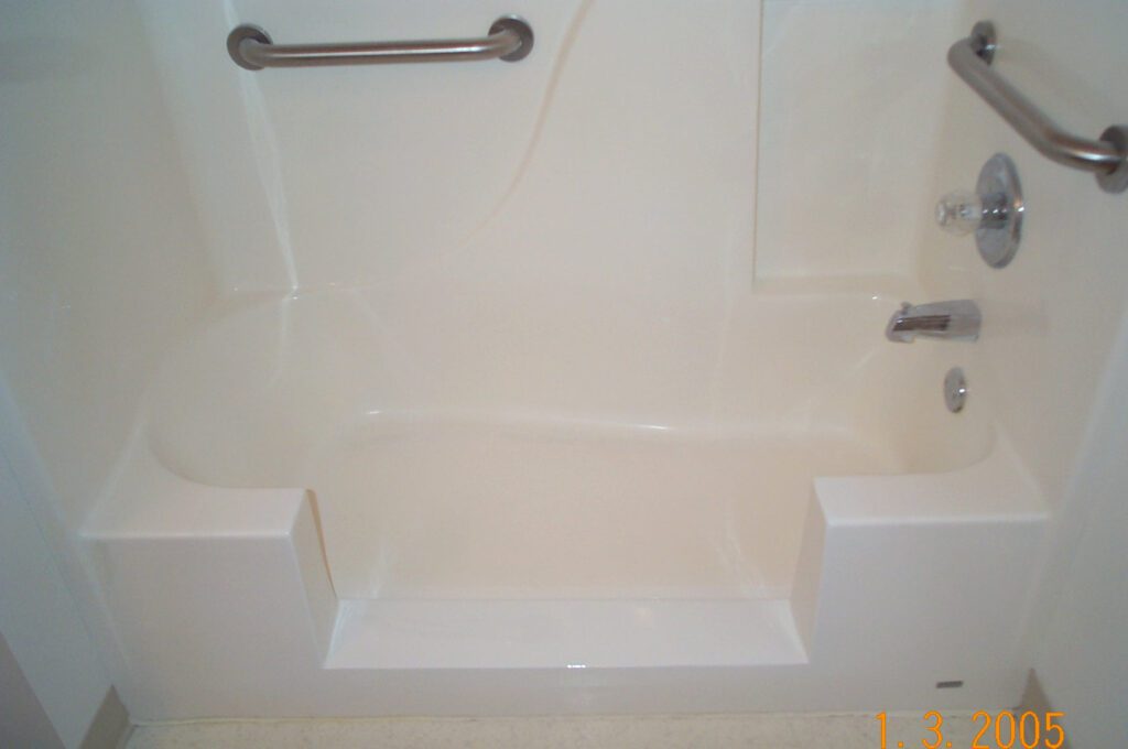 A small, shiny bathtub with an entry way